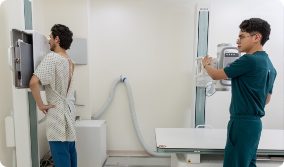 Técnico de Radiocare preparando a un paciente para una radiografía de tórax en la sala de rayos X