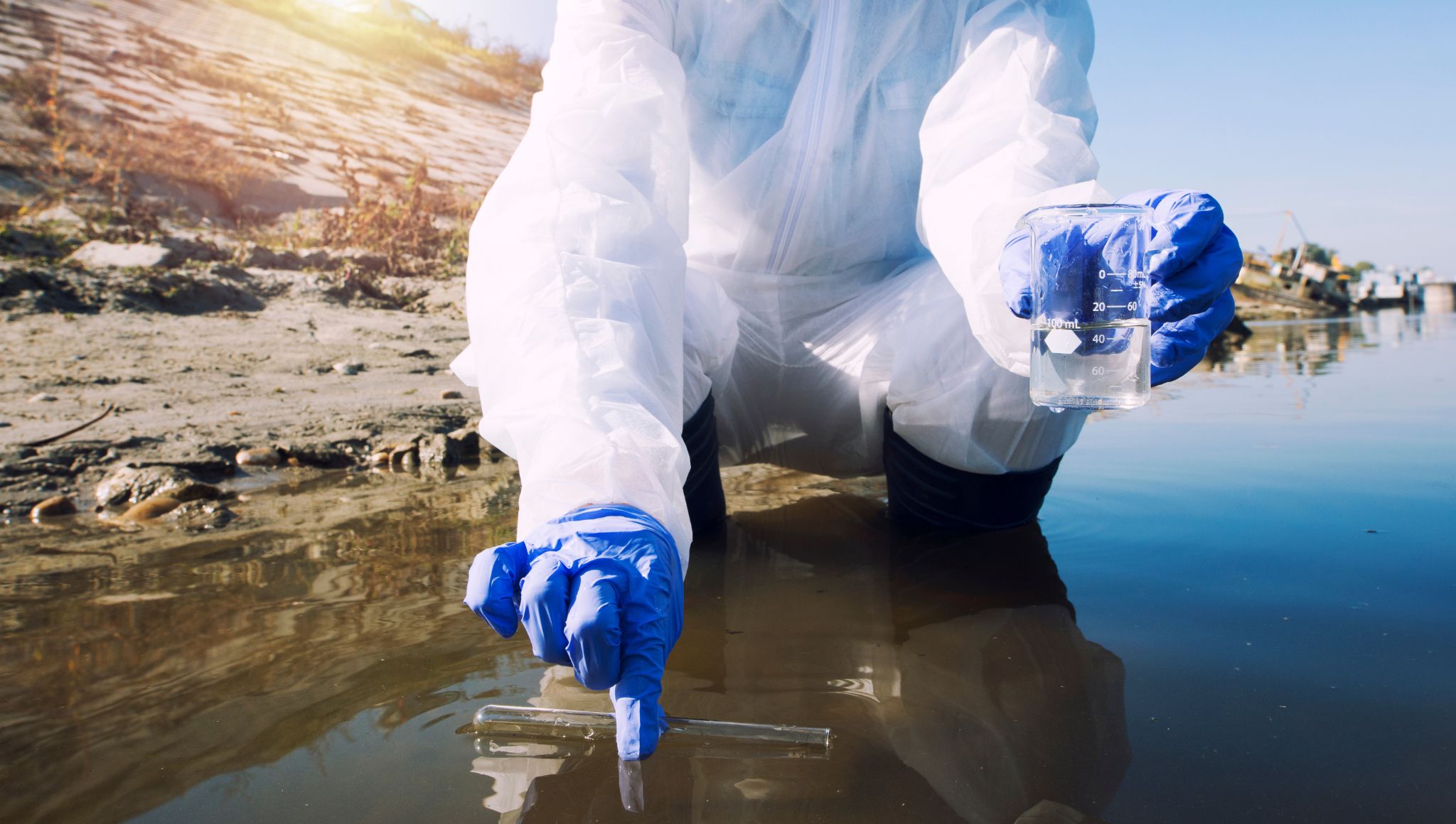 Persona con traje protector recogiendo basura para evitar enfermedades causadas por la contaminación del medio ambiente